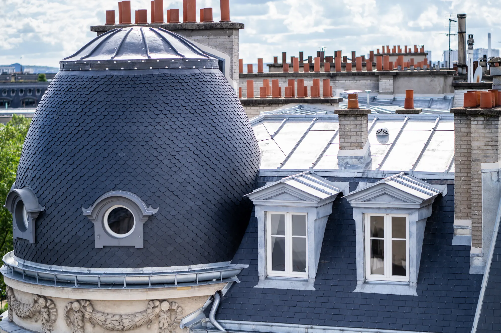 Dôme couvert d'ardoises en écailles et toiture en zinc d'un immeuble ancien