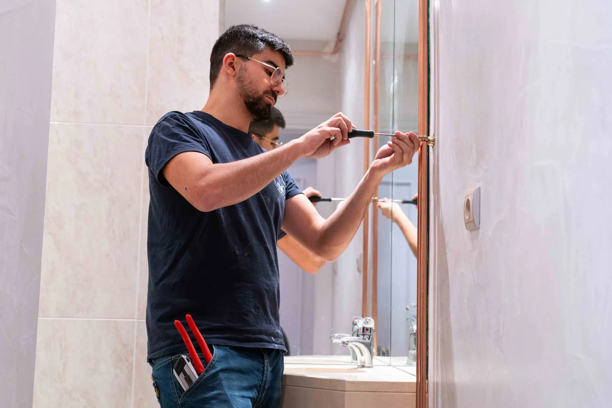 Plombier réglant une tuyauterie en cuivre dans une salle de bains